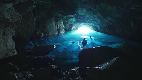 Tres-Hombres-Saltando-Al-Agua-Dentro-De-Una-Cueva-Azul-En-Las-Calas.-Marsella